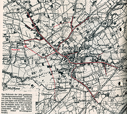 Historische Schwarzweiß-Karte von Isselhorst aus dem Jahr 1904, auf der Straßen, Feldwege und Siedlungskerne eingezeichnet sind; rote Linien markieren den Verlauf des damaligen Wasserleitungsnetzes um den Ort herum.